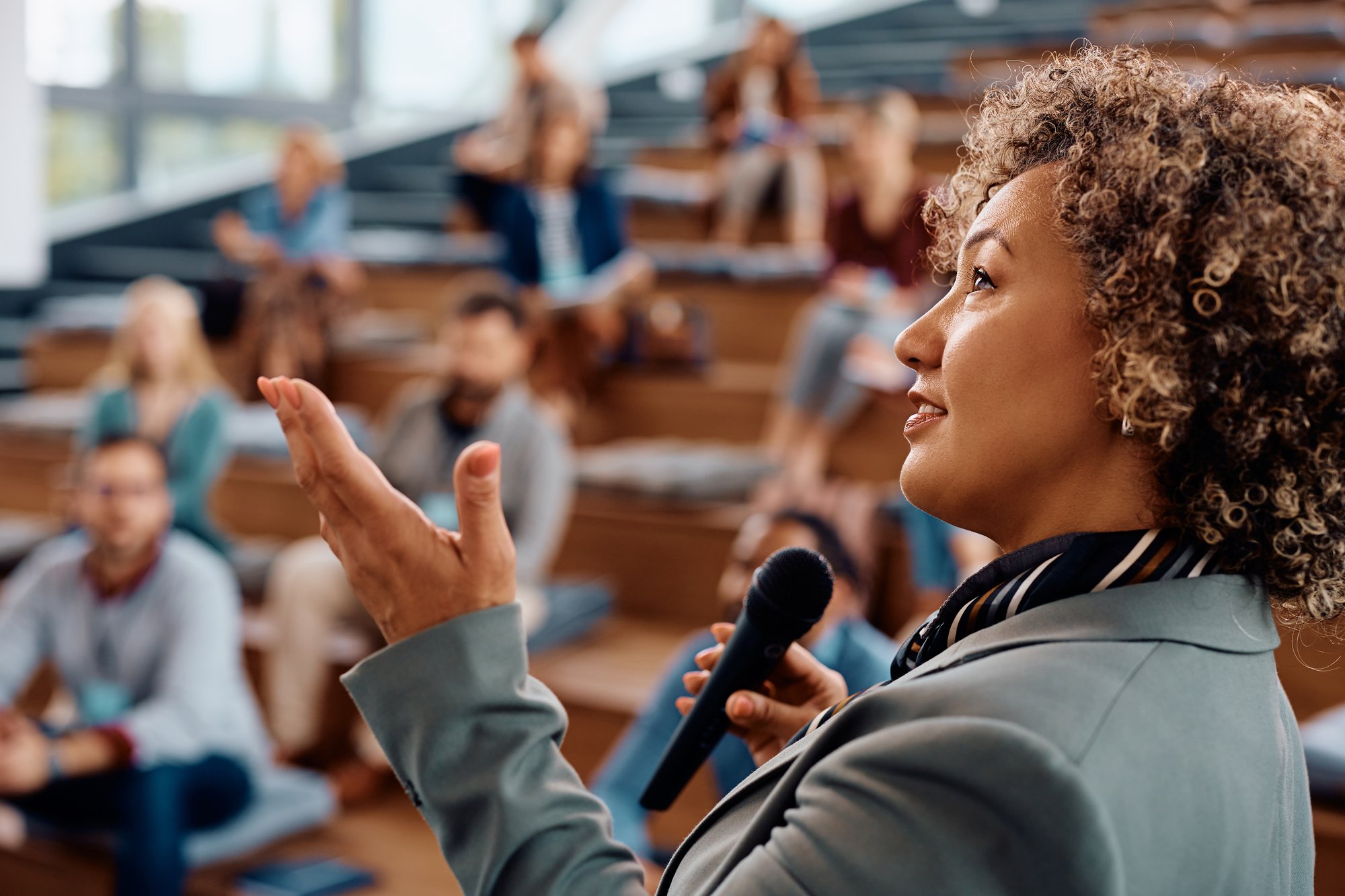 LEAD-mid-adult-businesswoman-giving-a-speech-to-group-o-2024-12-13-18-30-44-utc